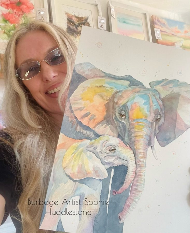 Sophie Huddlestone holding an elephant painting she created in watercolours