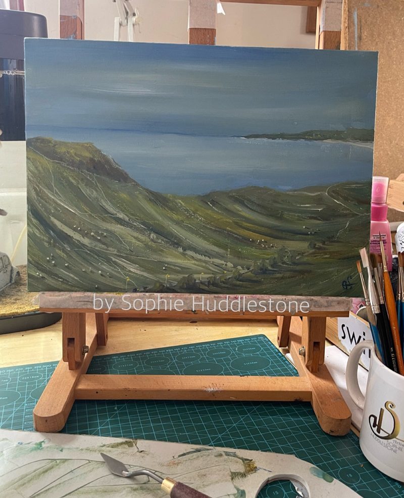 oil painting by Sophie Huddlestone of sheep on a field, hills, seascape, a drive to the seaside